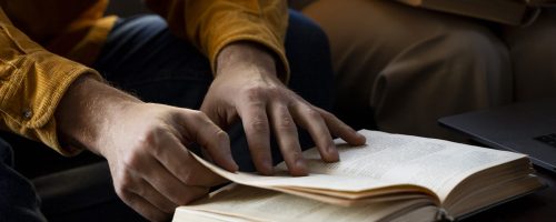 high-angle-hands-holding-book